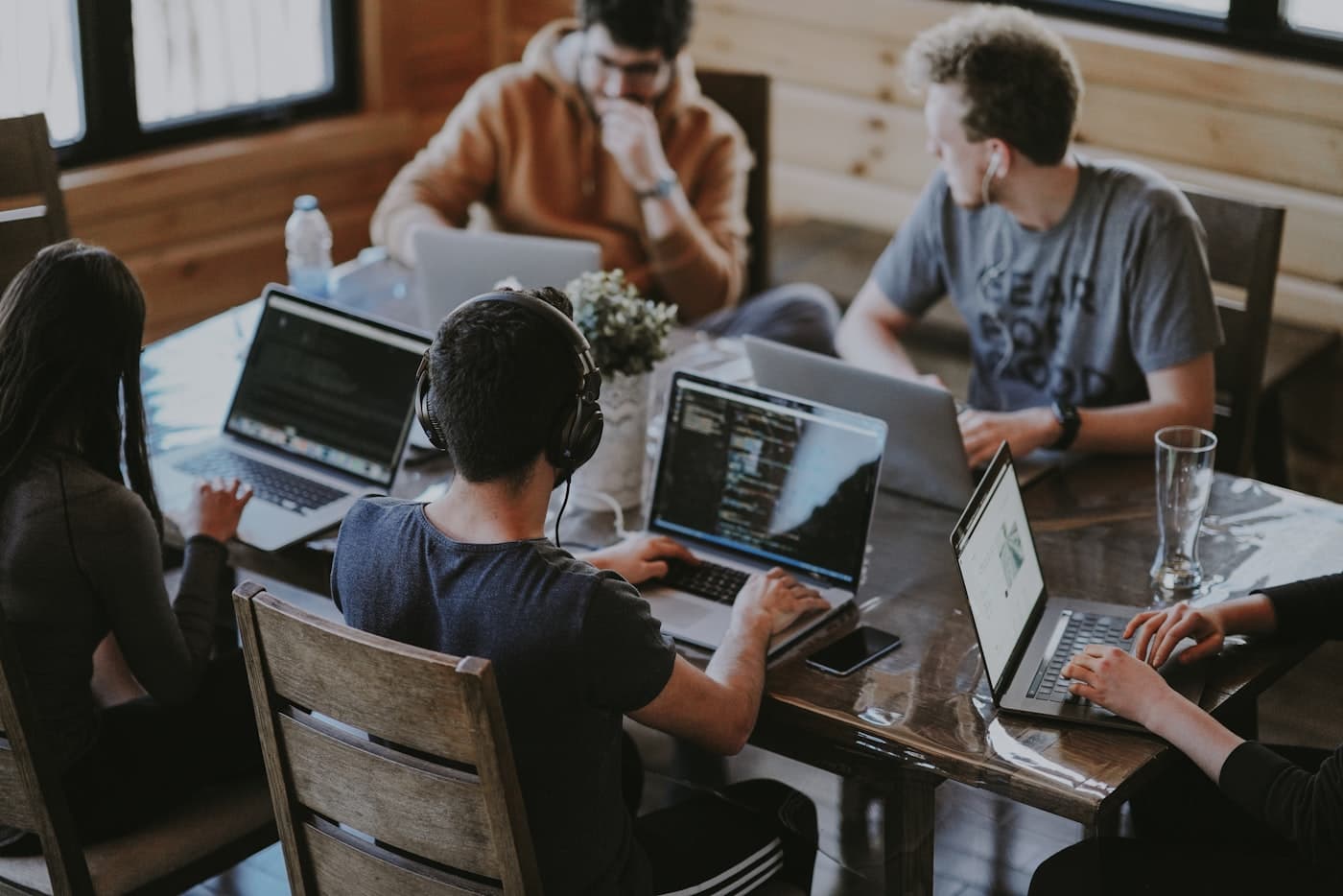 A group building together on laptops around a table